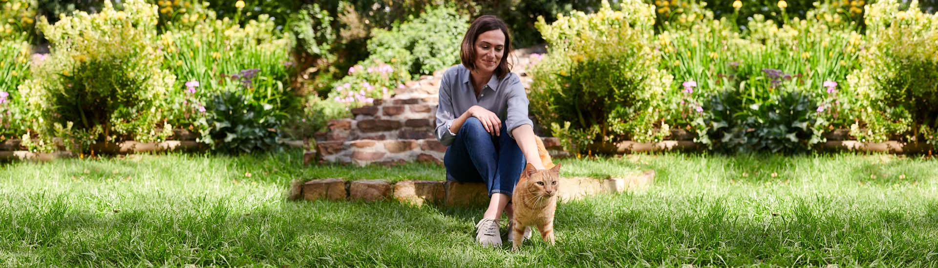 Frau mit Katze auf einer Wiese